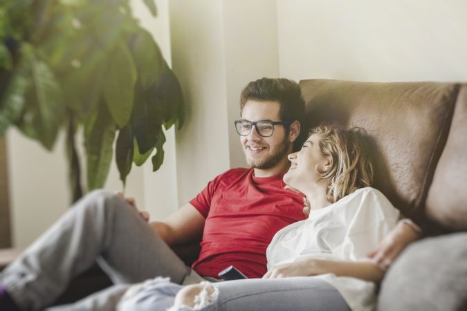 Happy couple watching TV on sofa