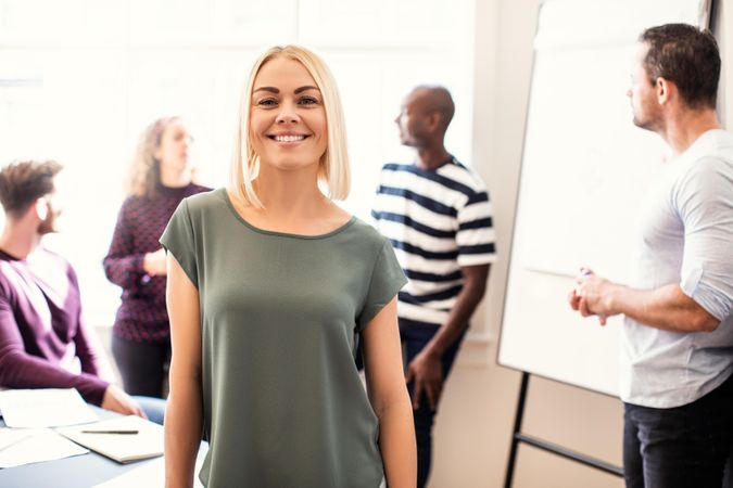 Blonde woman standing proudly in office