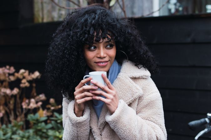Smiling Black woman with cup of coffee