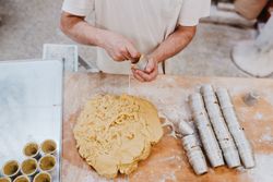 Unrecognizable cook putting pastry dough in cup