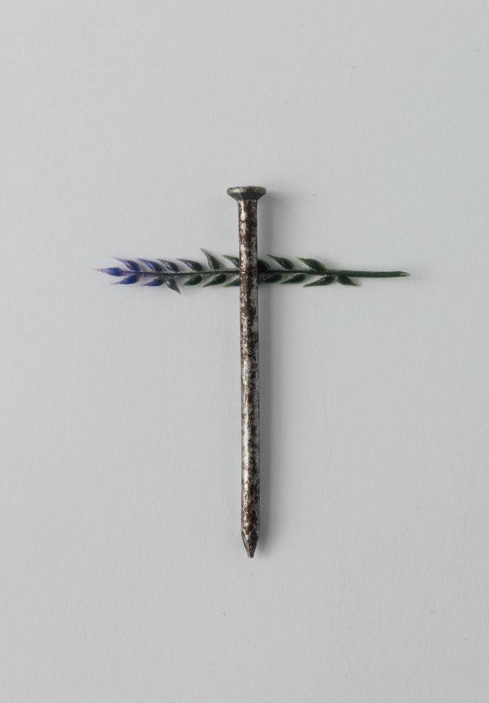 Nail on light background crossed with leaf