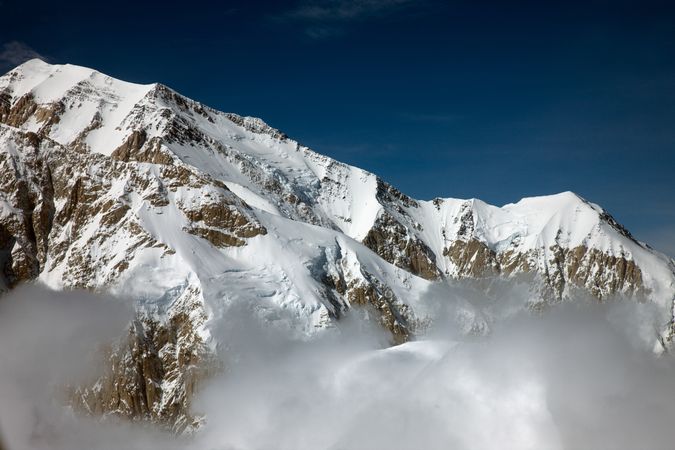 Snowy peak of Mount McKinley shrouded in clouds in Alaska