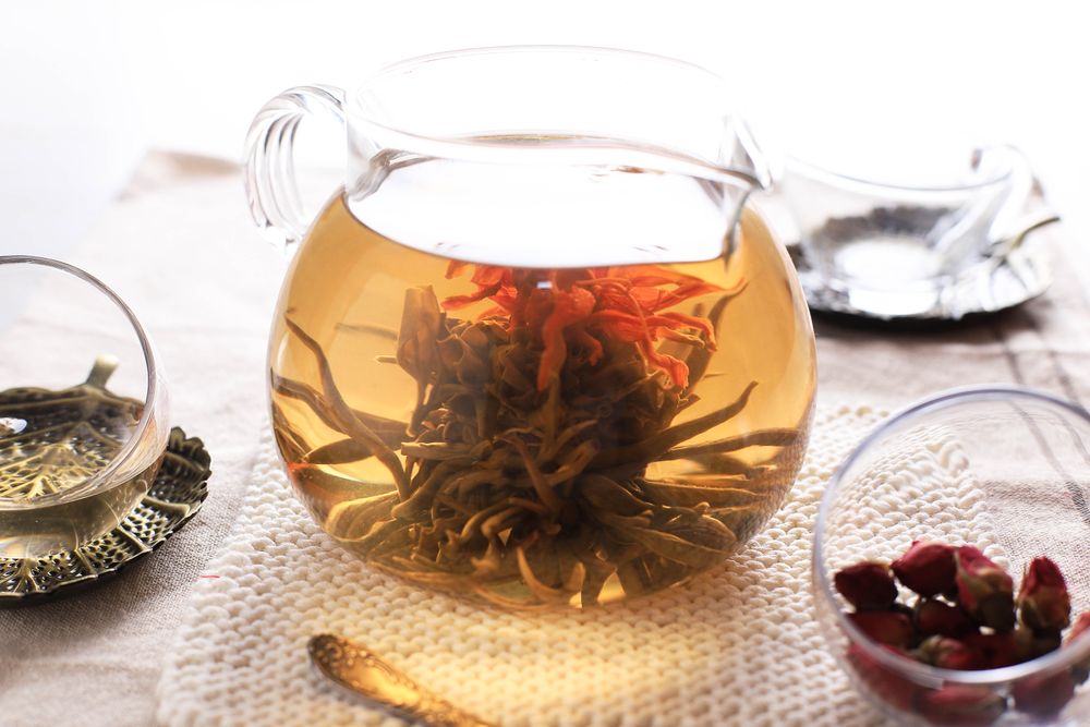 Teapot and Glass Cup with Blooming Tea Flower Inside