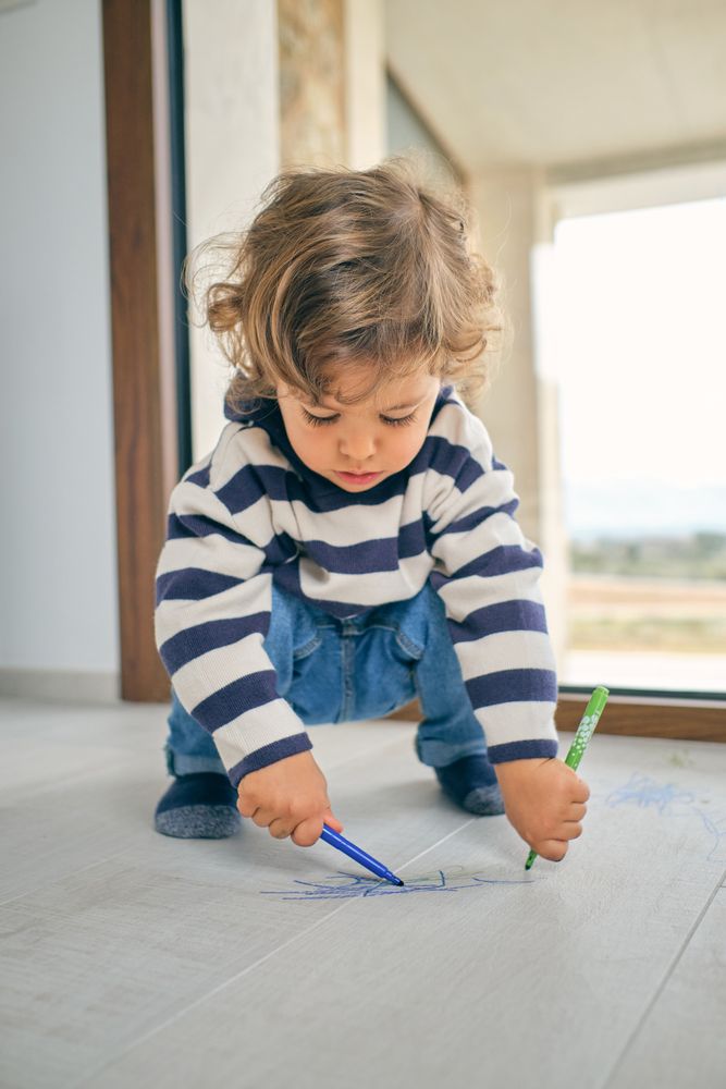 Concentrated toddler drawing on floor