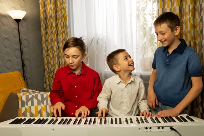 Boys playing the piano and enjoying music together at home