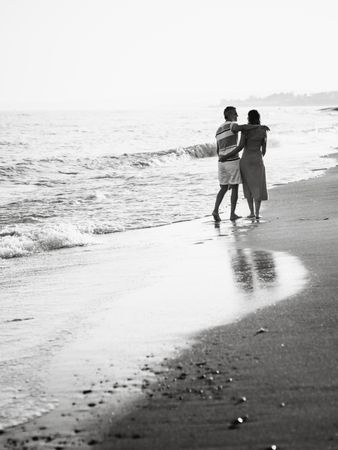 Adult couple walking towards sea