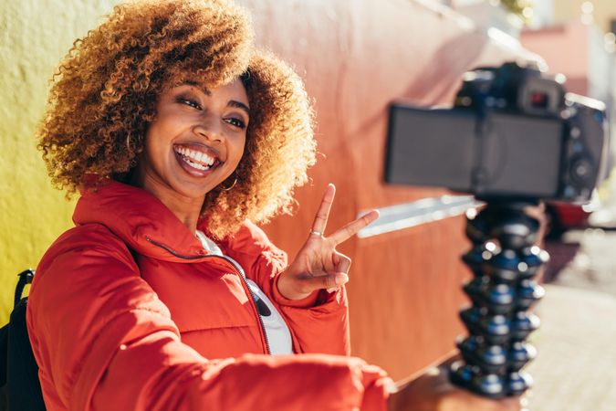 Smiling biracial woman traveller taking a selfie using her digital camera