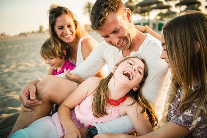 Beautiful happy family with playful children on beach