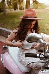 Woman sitting on pink motorbike