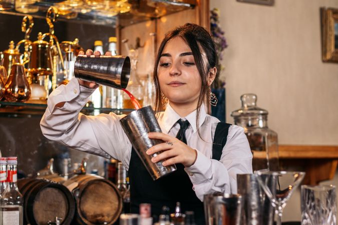 Female bartender preparing a cocktail in a traditional cocktail bar