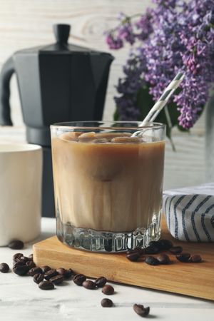 Composition with ice coffee and flowers on wooden background