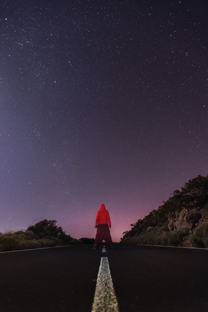 Traveler standing on empty road at night
