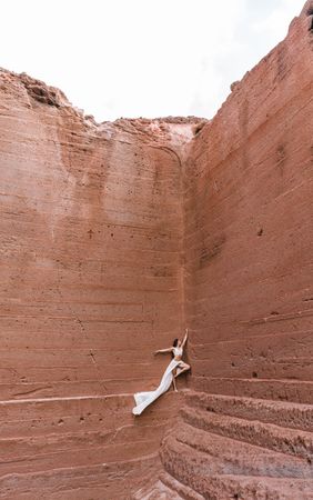 Elegant female posing on rocky cliff
