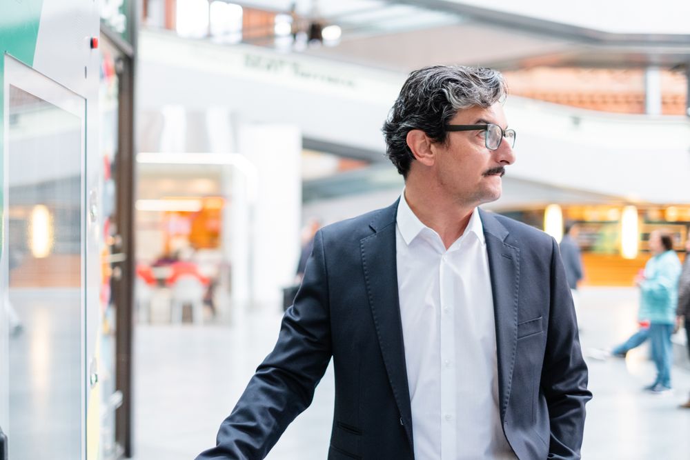 Puzzled mature businessman in stylish formal wear at shopping plaza