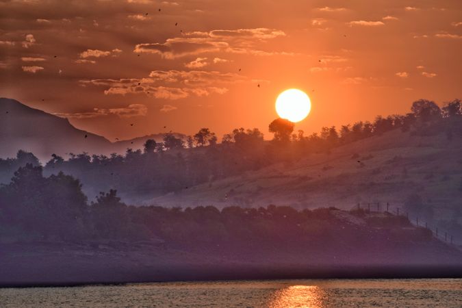 Sunset reflection on water near mountains