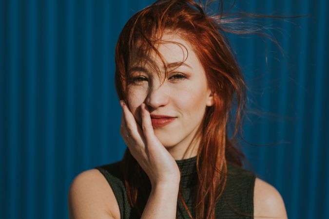Smiling woman squinting in sun and enjoying weather