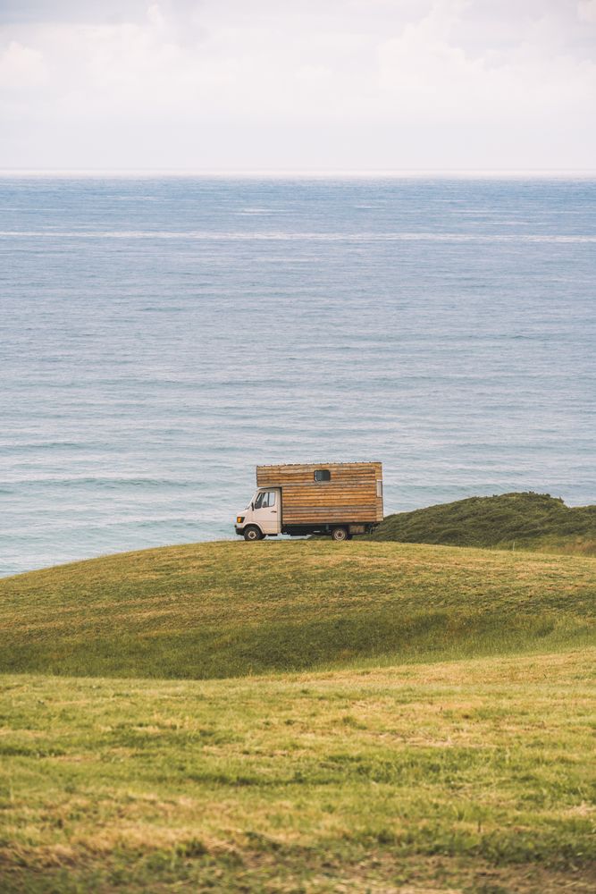 Landscape of empty meadow with passing truck near seaside