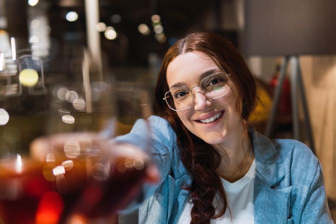 Happy businesswoman proposing toast during meeting