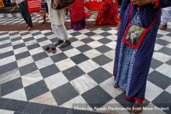 Downward angle of a woman’s dress and purse against a checkered tile floor in Rishikesh, India 0JG3K5
