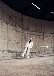 Young man posing in lean back stance in cement structure