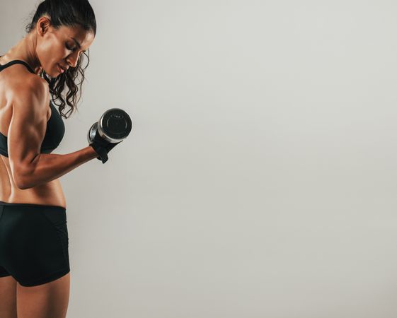 Fit young woman working out with a dumbbell