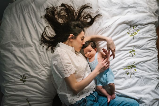 Mother and baby lying on bed