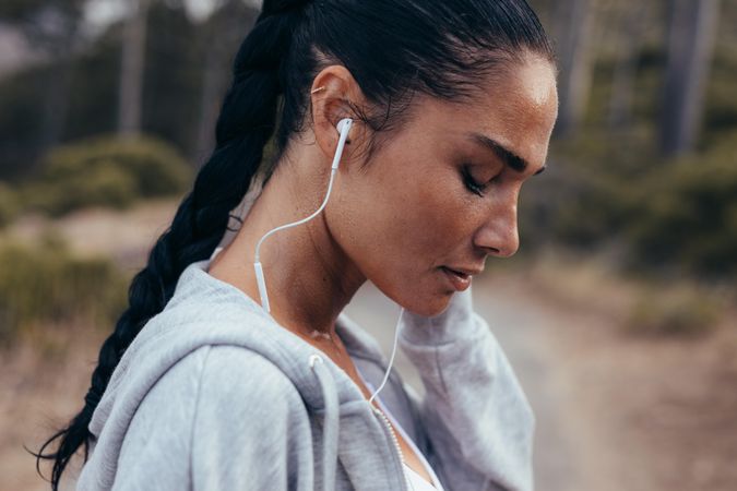 Side view of female athlete wearing earphones listening to music