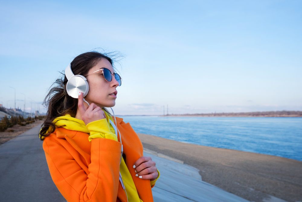 Woman wearing headphones on the coast