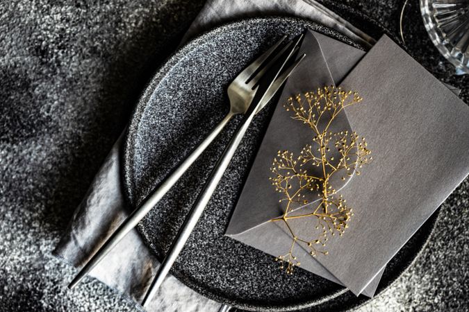 Minimalistic place setting with delicate dried flower and envelope
