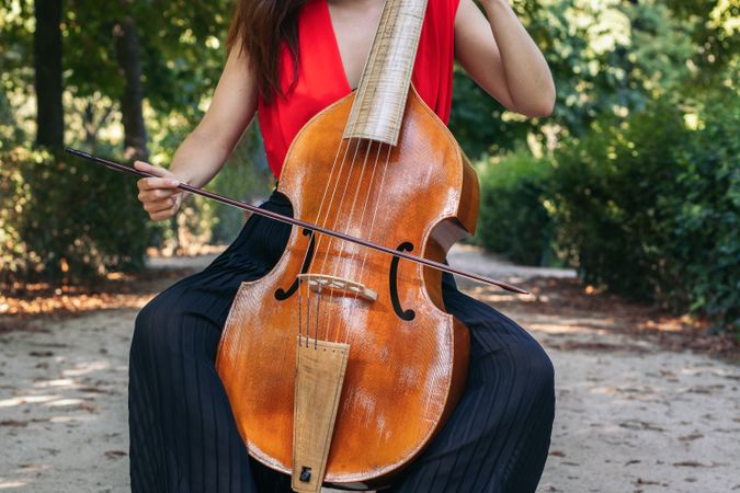 Woman playing the cello in a park.