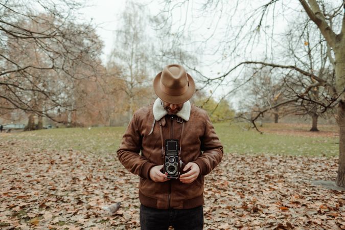 Male photographer standing in autumn park