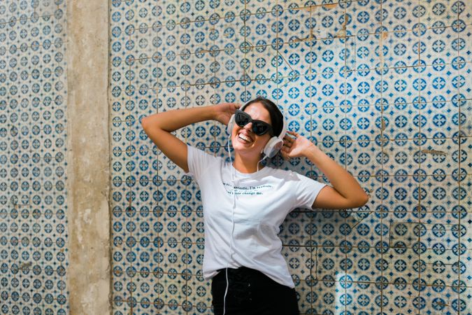 Cheerful casual woman in sunglasses standing on city street