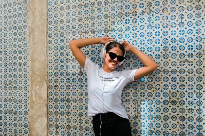 Cheerful casual woman in sunglasses standing on city street