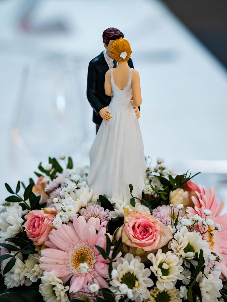 Wedding table decorations. Flowers, figurines of the bride and groom.