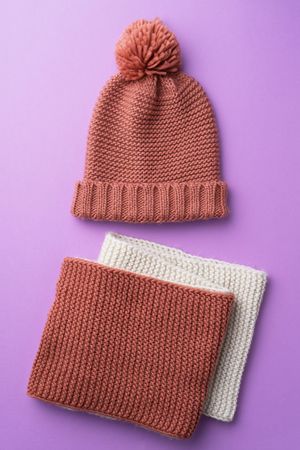 Knit scarf and beanie on purple background