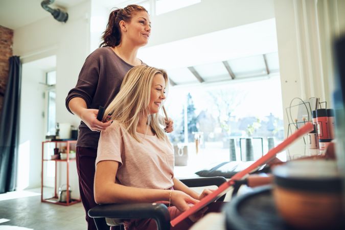 Female customer sitting in salon chair selecting hair color