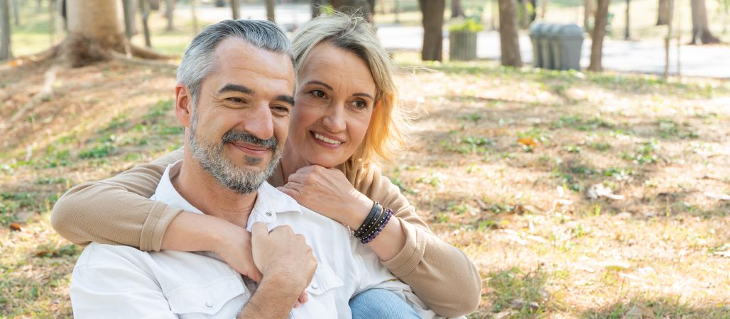 Affectionate mature man and woman sitting in park together