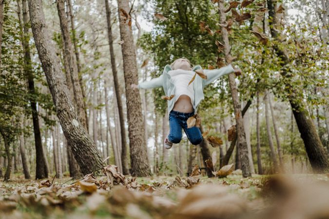 Smiling girl between meadow with dry leaves
