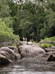 Two women in bathing suits on rocks near a mountain lake