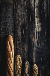Assorted gold homemade bread on dark wood background