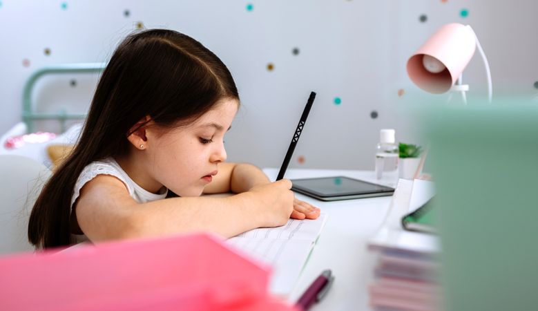 Girl doing homework sitting at a desk