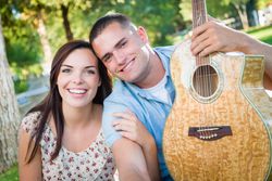 Young Adult Couple Portrait with Guitar in the Park.