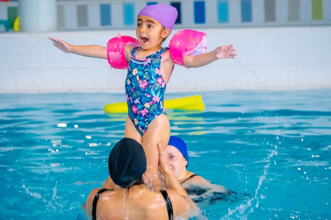 Mother playing with daughter in swimming pool