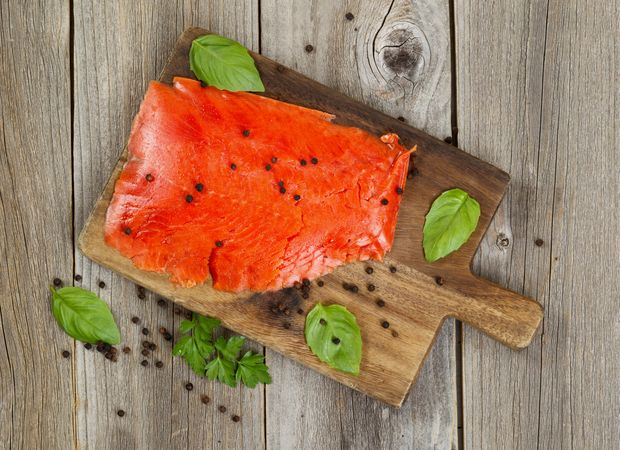 Cold smoke red salmon being prepared on wooden server board