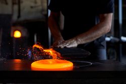 Crop craftsman forming liquid glass in workshop