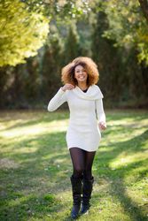 Confident woman walking through park on sunny day