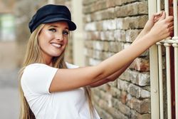 Smiling woman holding onto window railing