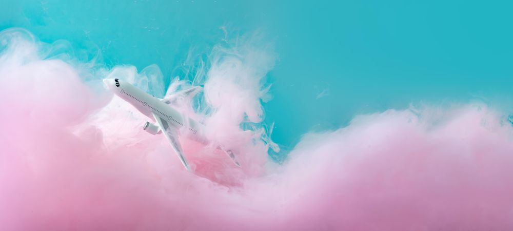 Cloud-like pink color paint with light  airplane on blue background