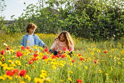 Boy and girl resting in blooming field