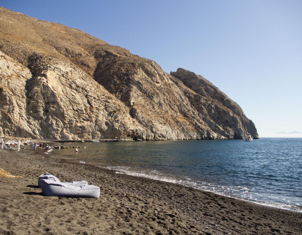 Two sunbeds on a dark sandy beach